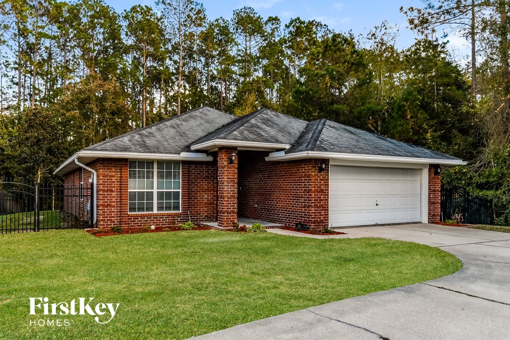 a small brick house with a garage and a driveway