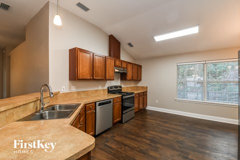 a kitchen with wooden cabinets and stainless steel appliances and a large window