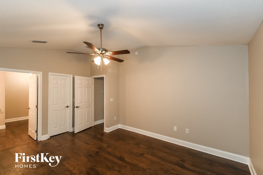 a living room with wood floors and a ceiling fan