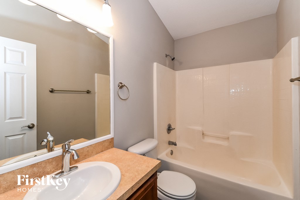 a bathroom with a shower toilet and sink and a mirror