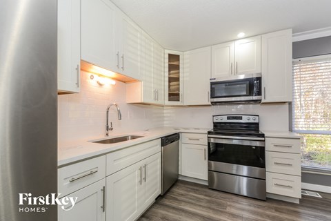 A kitchen with white cabinets and stainless steel appliances.