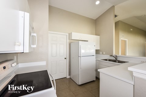 A kitchen with a black counter top and a white refrigerator.