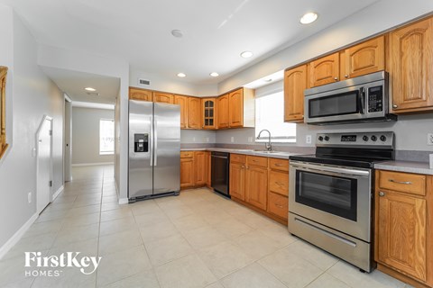 a large kitchen with stainless steel appliances and wooden cabinets