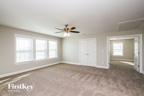 a living room with carpet and a ceiling fan