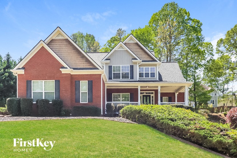 a red brick house with a green lawn in front of it