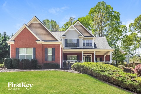a red brick house with a green lawn in front of it
