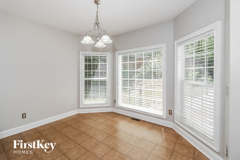 a dining room with large windows and a tiled floor