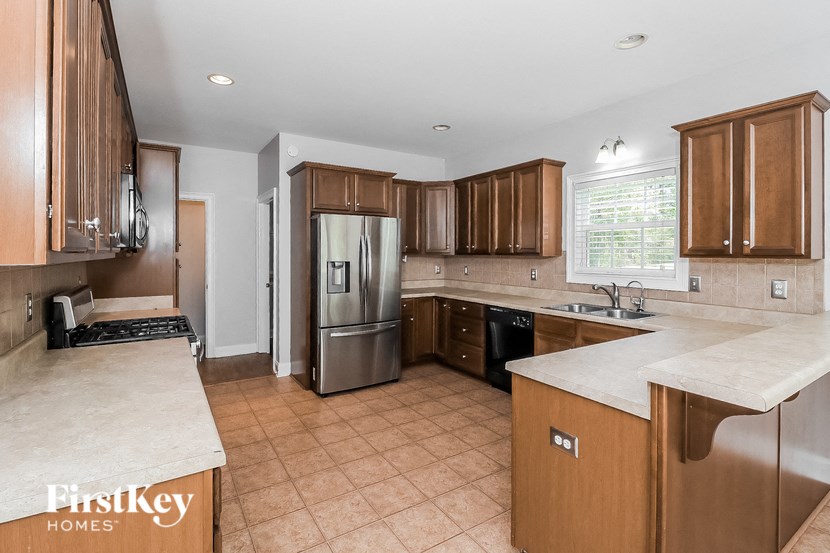 a kitchen with wooden cabinets and a stainless steel refrigerator