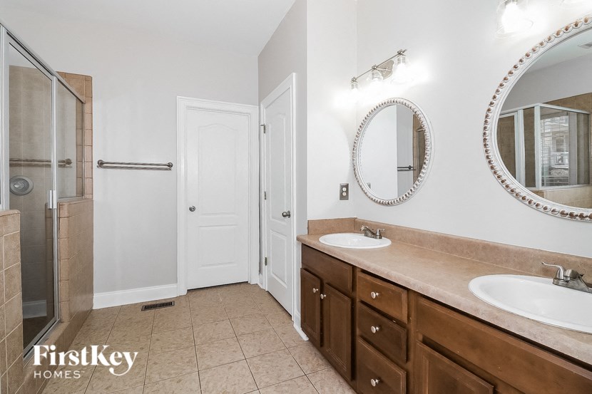 a bathroom with two sinks and a shower and a mirror
