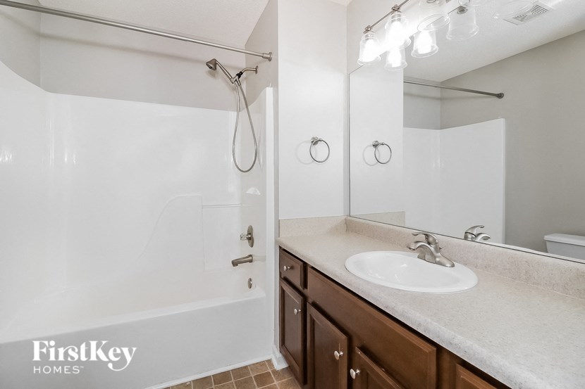 a bathroom with a sink and a shower and a mirror
