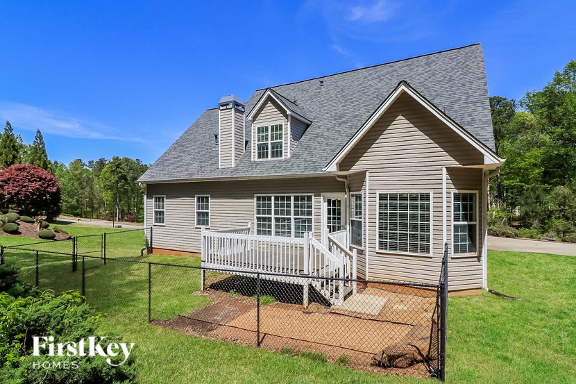 a small house with a porch and a fence