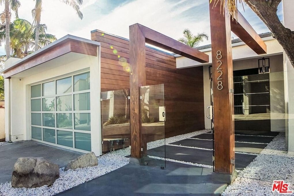 the front entrance of a modern home with a large glass door