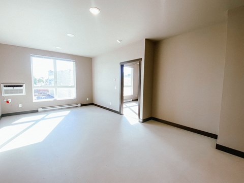 A large, empty room with a doorway leading to another room.