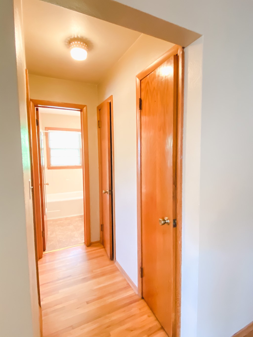 the door is open to the bathroom and the hallway to the bedroom is empty