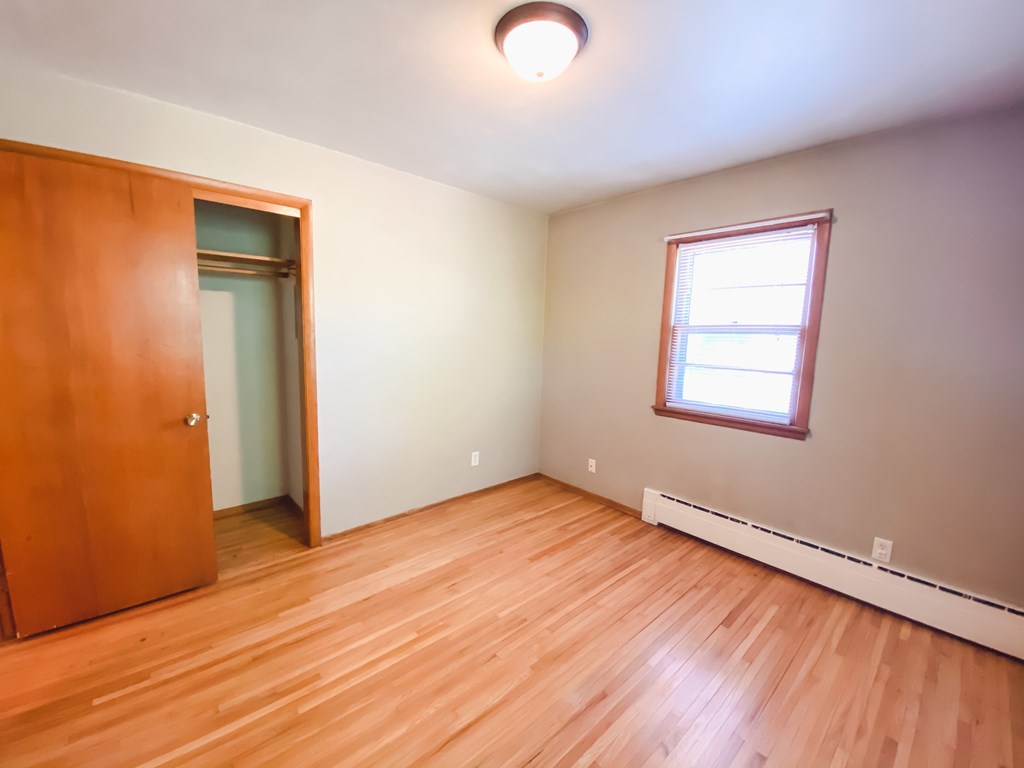 an empty room with wooden floors and a window