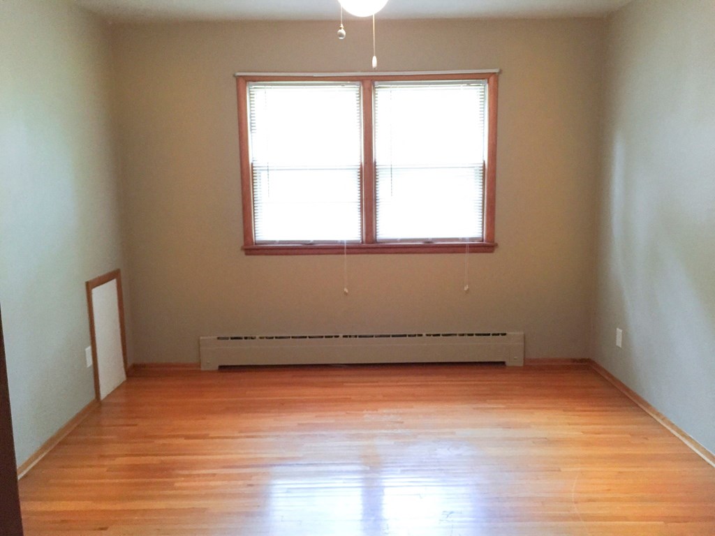 an empty room with a wood floor and a window