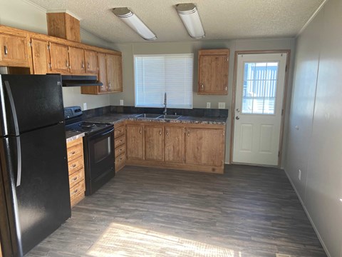 A kitchen with black appliances and wooden cabinets.