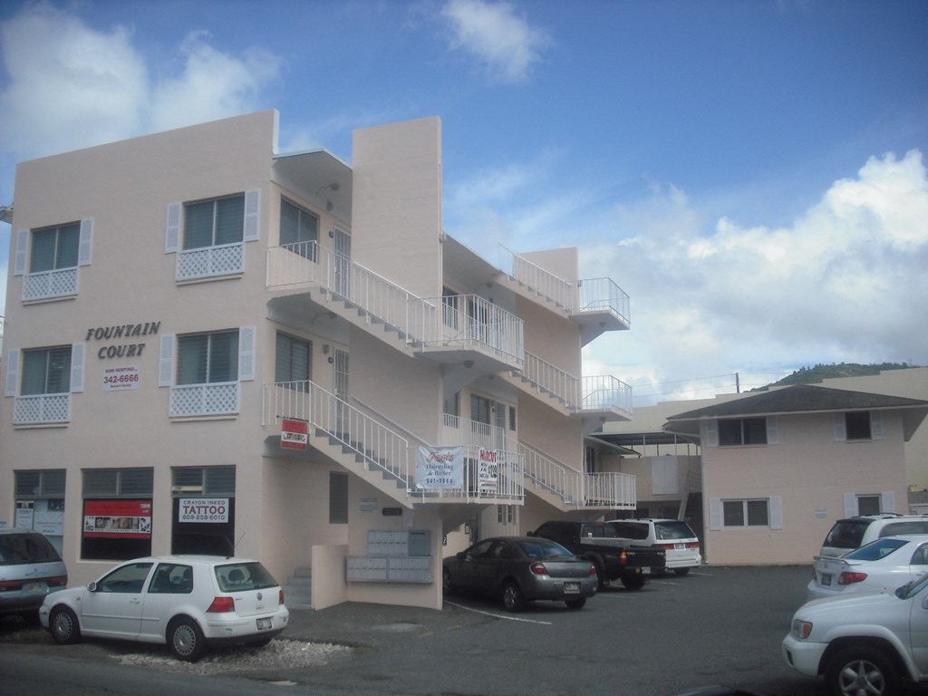 an apartment building with cars parked in front of it
