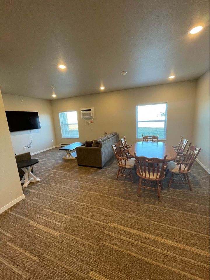 a living room with a table and chairs and a television