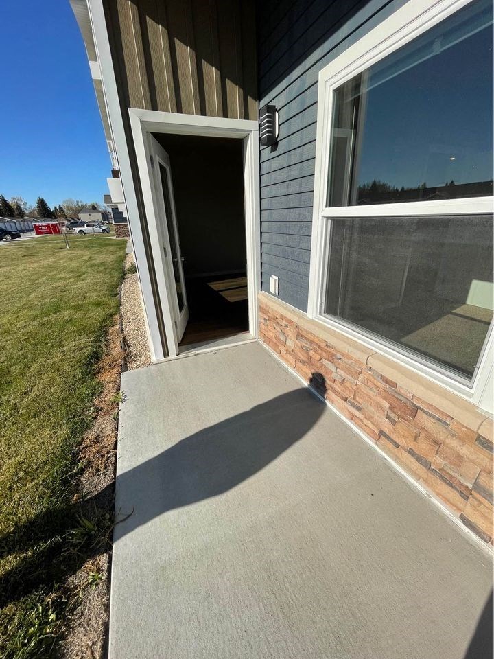 a covered porch in front of a house with an open door