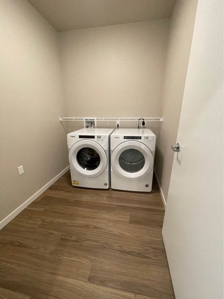 a washer and dryer in a laundry room with wooden floors