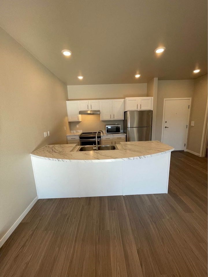 an empty kitchen with a marble counter top
