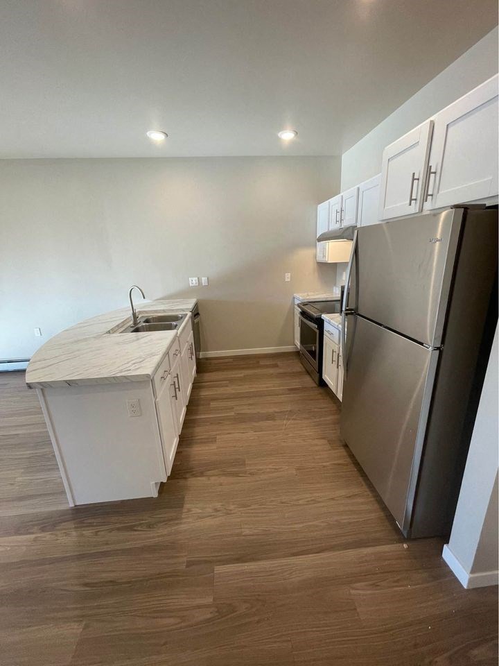 a kitchen with stainless steel appliances and a wooden floor