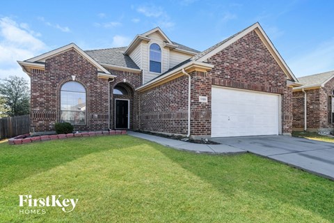 a brick house with a white garage door and a lawn