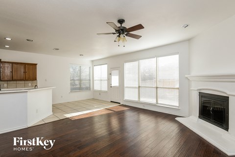 a living room with a fireplace and a ceiling fan