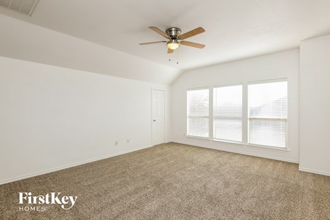a living room with carpet and a ceiling fan
