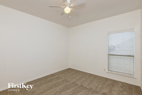 a bedroom with a ceiling fan and a window