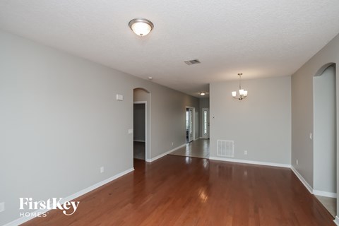 A spacious room with wooden floors and white walls.