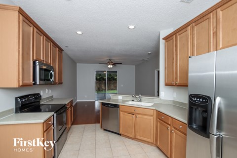 A kitchen with wooden cabinets and a stainless steel refrigerator.