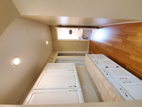 an overhead view of a kitchen with white cabinets and a wood floor