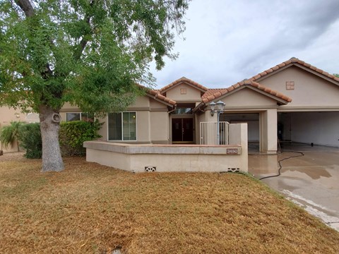 a house with a patio and a tree in front of it