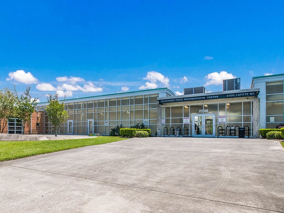 an office building with a driveway and a blue sky