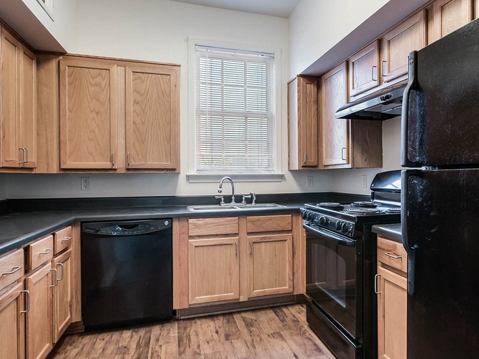 a kitchen with black appliances and wooden cabinets