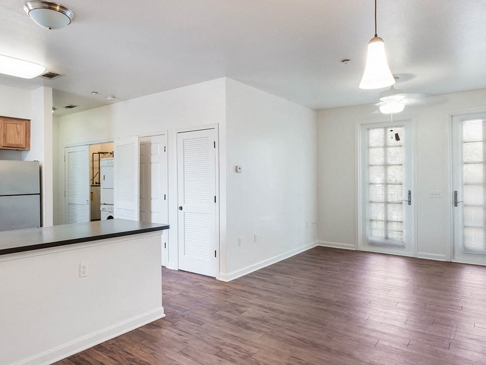 an empty kitchen and living room with a hard wood floor
