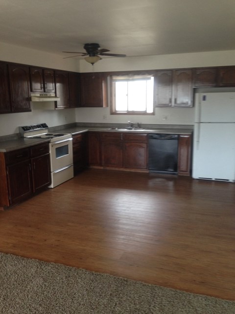 A kitchen with wooden cabinets and a white refrigerator.