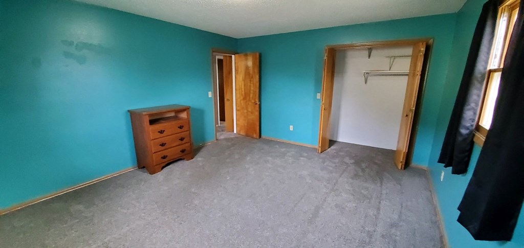 a room with blue walls and a closet and a dresser