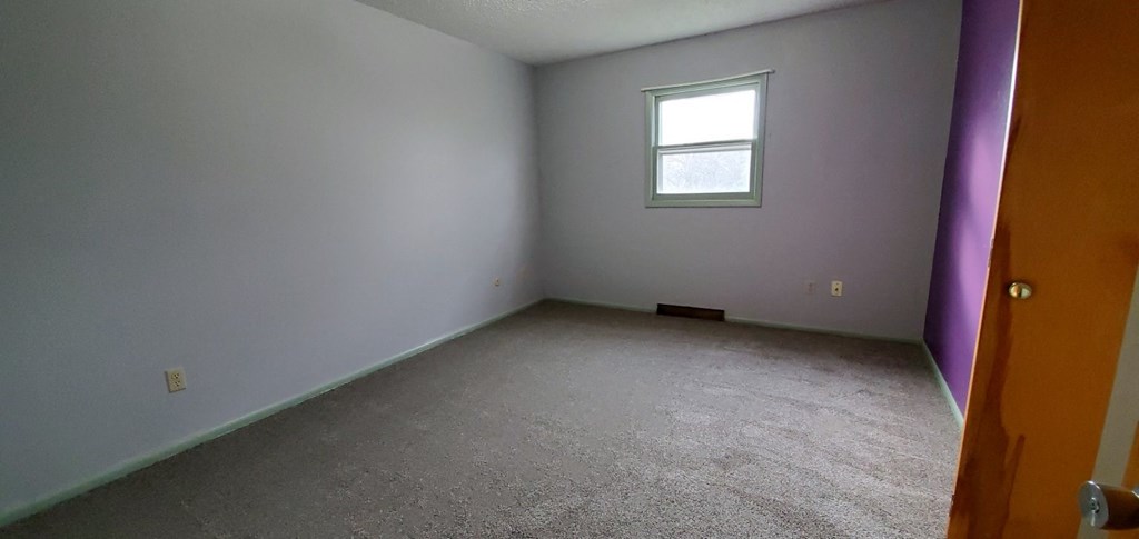 an empty room with a window and a door