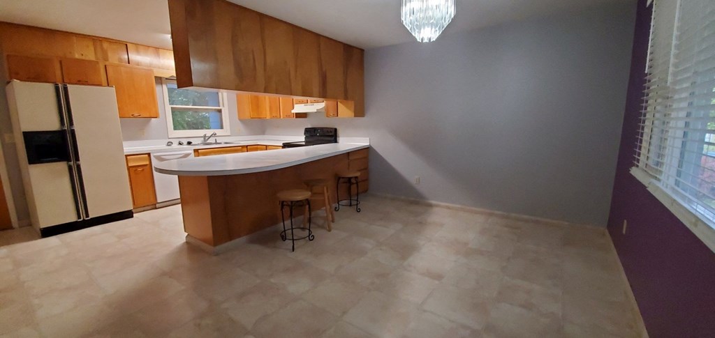 an empty kitchen with an island and wooden cabinets