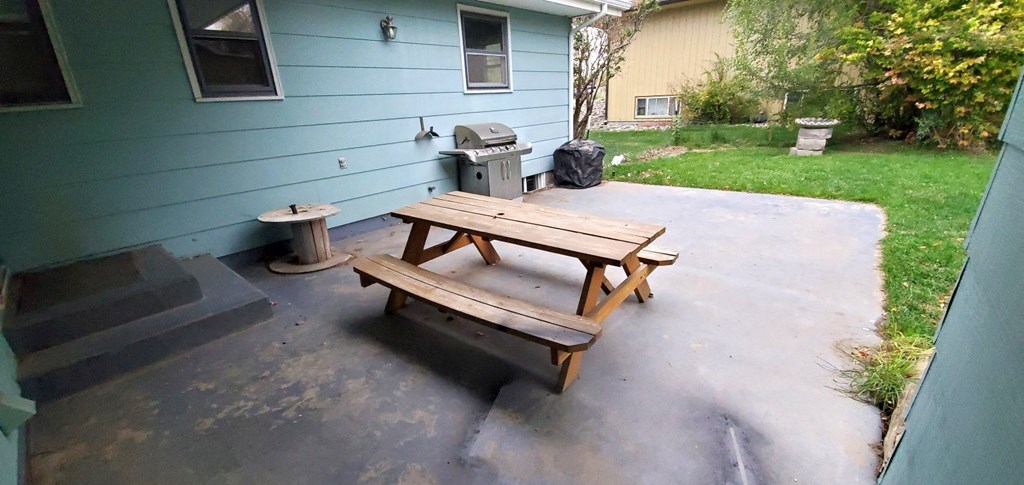 a picnic table on a patio in front of a house