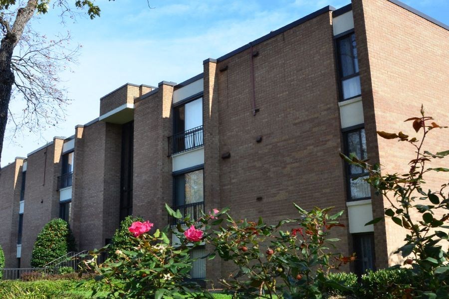 an apartment building with flowers in front of it