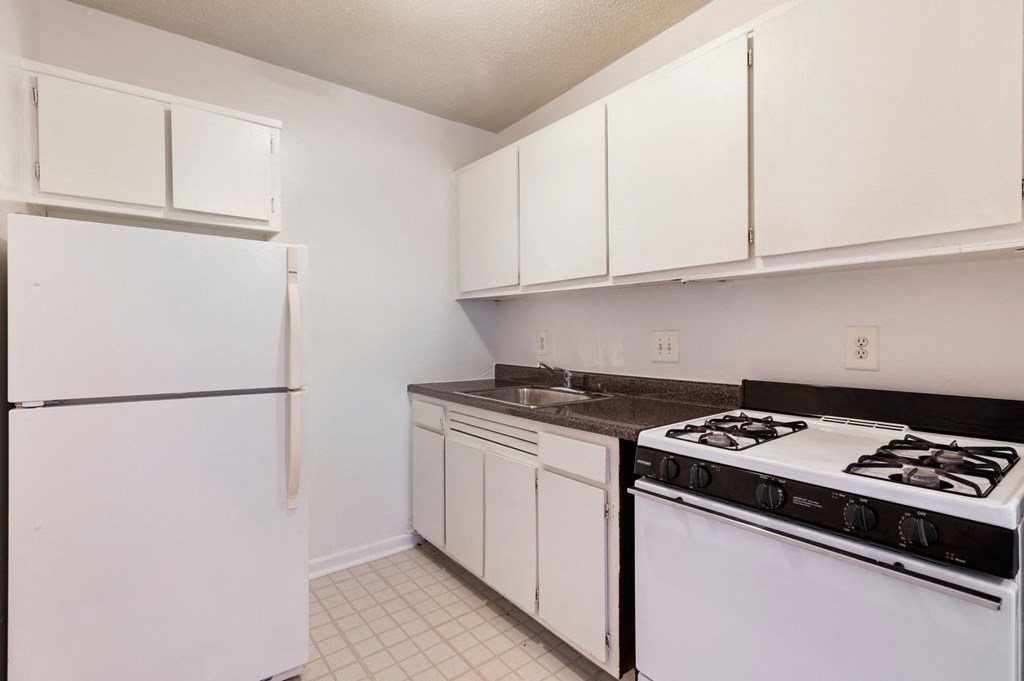 a kitchen with white cabinets and a stove and refrigerator