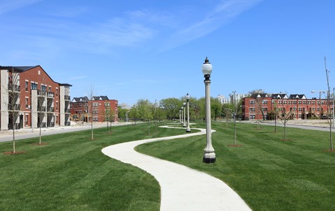a walkway through a grassy area on a college campus