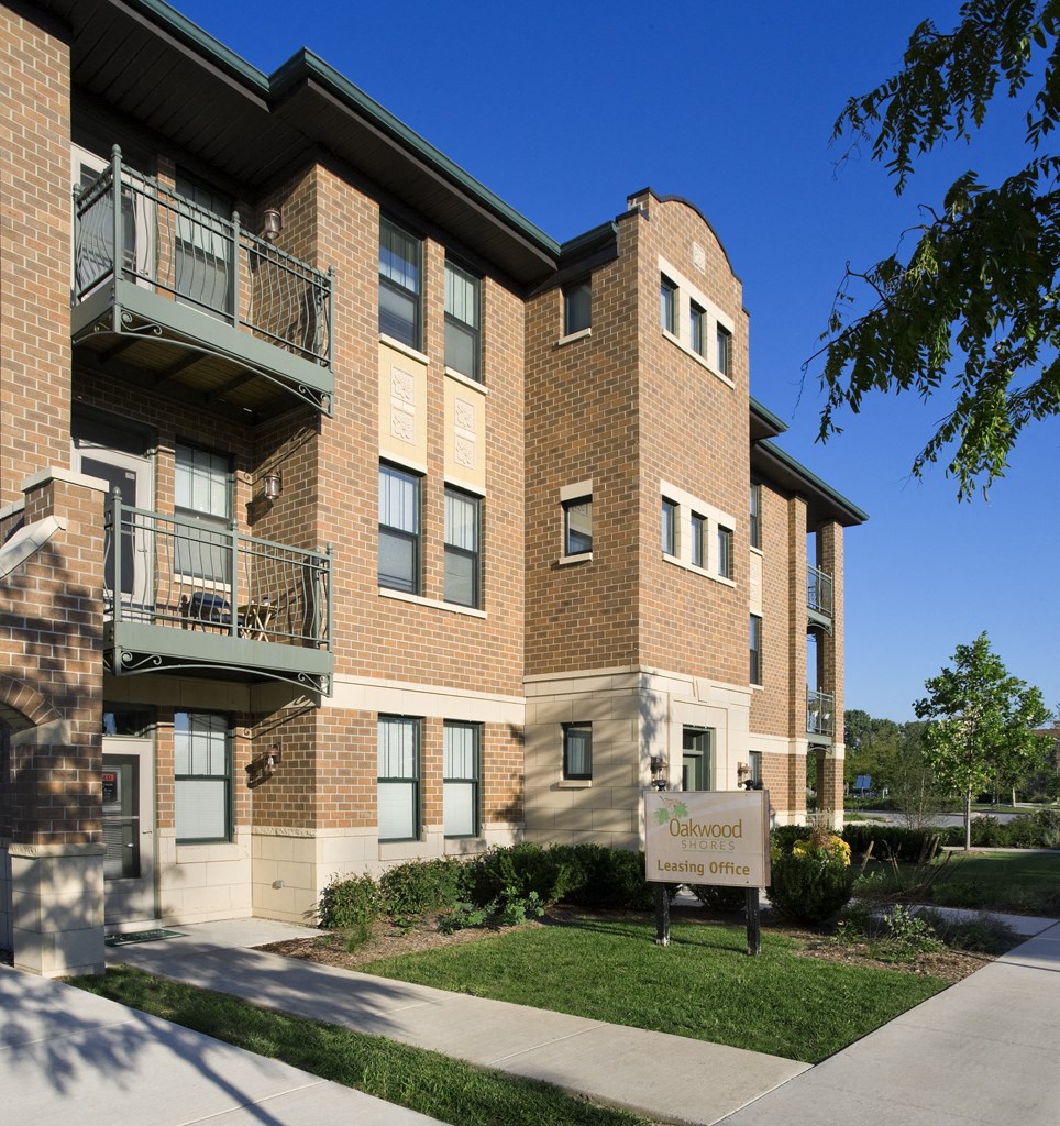 a brick apartment building with a sign in front of it