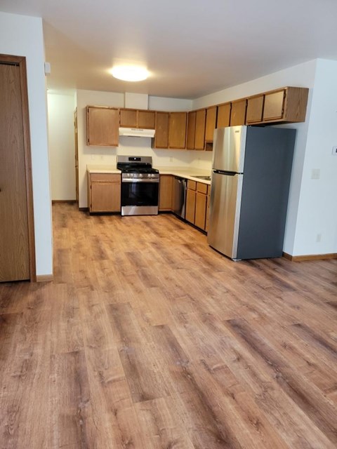 A kitchen with wooden cabinets and a refrigerator.