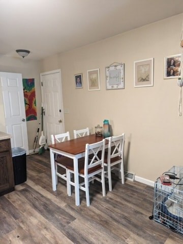A dining room with a wooden table and chairs.