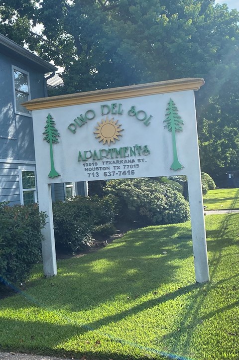 A sign for Pino Del Sol Apartments in Houston, Texas.